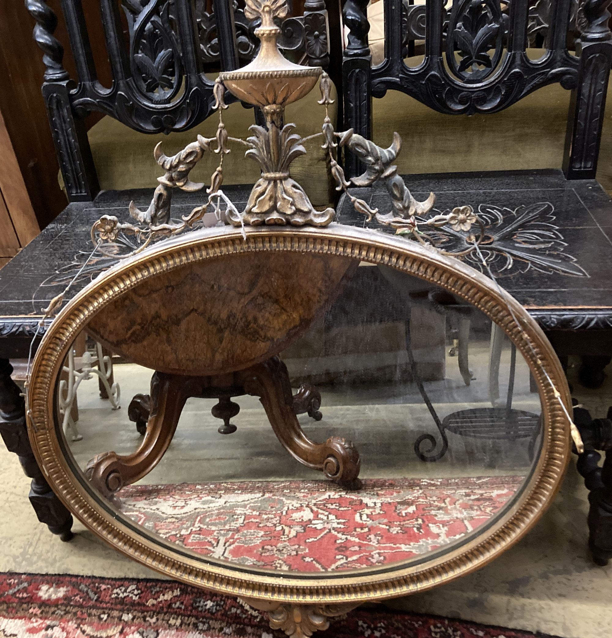 An oval Adams design giltwood and gesso wall mirror, with urn and husk cornice, width 66cm, height 82cm